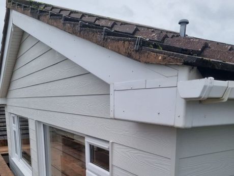 White fascia boards and gutters on a grey house
